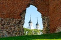 Ancient stone and red brick castle ruins with church towers in the background Royalty Free Stock Photo