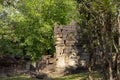 Ancient stone ruin in Angkor Wat temple. Carved stone wall in green forest. Khmer heritage temple ruin in jungle.