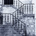 Ancient stone staircase with ornate wrought handrail Royalty Free Stock Photo