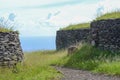 Ancient stone structures at Orongo Village overlooking the blue ocean Royalty Free Stock Photo