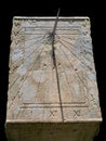 Ancient stone sundial isolated on black