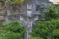 Ancient stone tombstone in form of crucified Jesus on cemetery Royalty Free Stock Photo