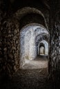 Ancient stone tunnel leading to a light-filled door Royalty Free Stock Photo