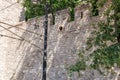 Ancient stone wall with battlements and lamp post amidst greenery Royalty Free Stock Photo
