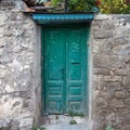 Ancient stone wall green colored wooden door