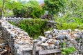 An ancient stone wall of a ruined house amongst the grass. Old house, ruins, background Royalty Free Stock Photo