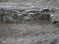 Ancient stone wall under reconstruction with rocks methodically stacked in sandy soil Royalty Free Stock Photo