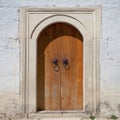 Ancient stone wall with wooden arch door