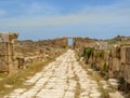 Old Roman street leading to gateway at ancient Roman ruins of Leptis Magna in Libya Royalty Free Stock Photo