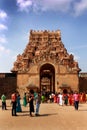 People walk in front of the ancient temple facade of Brihadisvara Temple in Thanjavur, india.