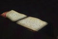 Ancient Tibetan Buddhist sacred manuscript in Uchen script illuminated by ray of light inside monastery. Himalayan sutra Royalty Free Stock Photo