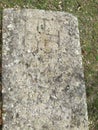 Ancient tombstone with cross in local cemetery Royalty Free Stock Photo