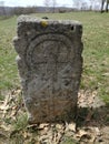 Ancient tombstone with cross in local cemetery Royalty Free Stock Photo