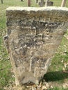 Ancient tombstone with cross in local cemetery Royalty Free Stock Photo