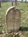 Ancient tombstone with cross in local cemetery Royalty Free Stock Photo