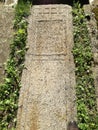 Ancient tombstone with cross in local cemetery Royalty Free Stock Photo