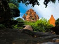 The ancient towers of Ponagar are seen from the dense vegetation of the park.