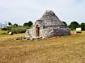 Ancient Trulli, traditional very old houses with olive trees and hay bales in Italy