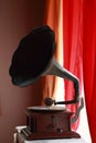 Ancient Turntables Placed by the window with red curtains hanging.