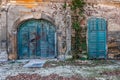 Ancient turquoise colored wooden entrance doors sprayed with graffiti