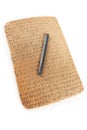 Cuneiform written in brown clay with rest of sand dirt and writing tool