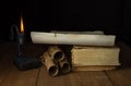 Ancient Unfolded and Rolled Scrolls, Ancient Books and a burning candle Royalty Free Stock Photo