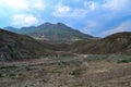 Ancient valley with the Crimean green hills covered with grass, mountain ranges with peaks, blue cloudy sky