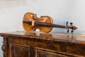 Ancient Violin Resting on an Antique Wooden Furniture