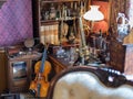 Ancient Violin resting on the Ground between Antique Furniture and Old Objects