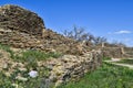 Ancient Walls and a Path to the Past with Squares of Yellow Flowers Under a Blue Sky