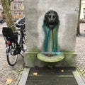 Ancient Waterfountain or pump shaped like a lion with a bike parked next to it in the city of Utrecht, The Netherlands