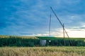 Ancient well with clean water. Ecology, getting water. Shadoof at sunset in Moldova, Cloudy sky and meadow with old working sweep Royalty Free Stock Photo