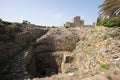 Ancient well inside the Roman ruins of Byblos and in the background the crusader castle. Byblos, Lebanon Royalty Free Stock Photo