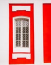 Ancient white cathedral`s window with a lattice in red wall. Church window in a classical style. Bright part of old building. Royalty Free Stock Photo