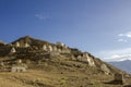 A ancient white Tibetan Buddhist temples stupas on the slope of a desert hill against the blue sky and mountain valley Royalty Free Stock Photo