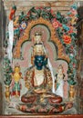 An ancient white tibetan deity statue with three heads in a monastery