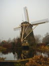 Ancient windmill on the shore of a lake. Royalty Free Stock Photo