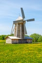 Ancient windmill with thatched roofing in a green meadow