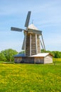 Ancient windmill with thatched roofing in a green meadow