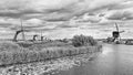 Ancient windmills on a canal with dramatic shaped clouds, Kinderdijk, The Netherlands