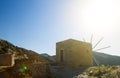 Ancient windmills against a bright blue sky and sun of Lasithi Plateau on Crete, Greece Royalty Free Stock Photo