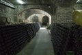 Wine cellar with oak barrels and shelves with bottles of Royalty Free Stock Photo