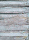 An ancient wooden background with peeling paint. The boards are blue. The boards are parallel. Texture. Background. Vertical photo