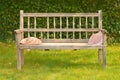 Ancient wooden bench in a garden with two straw hats Royalty Free Stock Photo