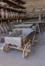 Ancient wooden cart and shelves with clay amphorae in Pompeii, Italy. Antique culture concept. Pompeii ruins.