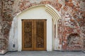 Ancient wooden church door with carvings of saints and red brick wall St. George the Martyr Church, Kaunas, Lithuania Royalty Free Stock Photo