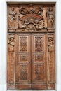 Ancient wooden church portal with sculptures and decorations in Piedmont, Italy