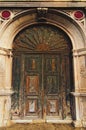 Ancient wooden door with arc in brick wall. Elements of architectural decoration of building. Venice, Italy Royalty Free Stock Photo