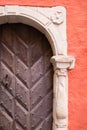 An ancient wooden door in the archway against the backdrop of a terracotta wall. Royalty Free Stock Photo