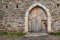 Ancient wooden door in old stone castle wall. Royalty Free Stock Photo